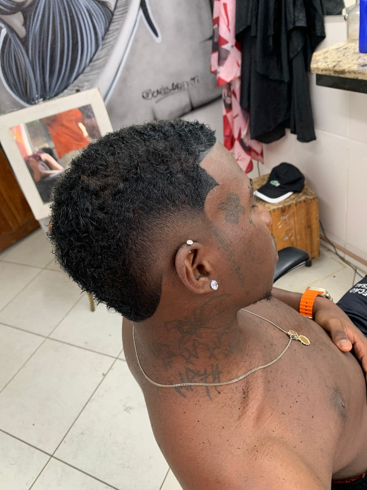 Corte cacheado com degradê e shape-up no contorno